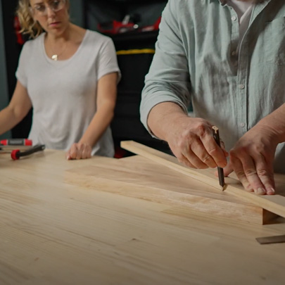A man draws on a piece of wood