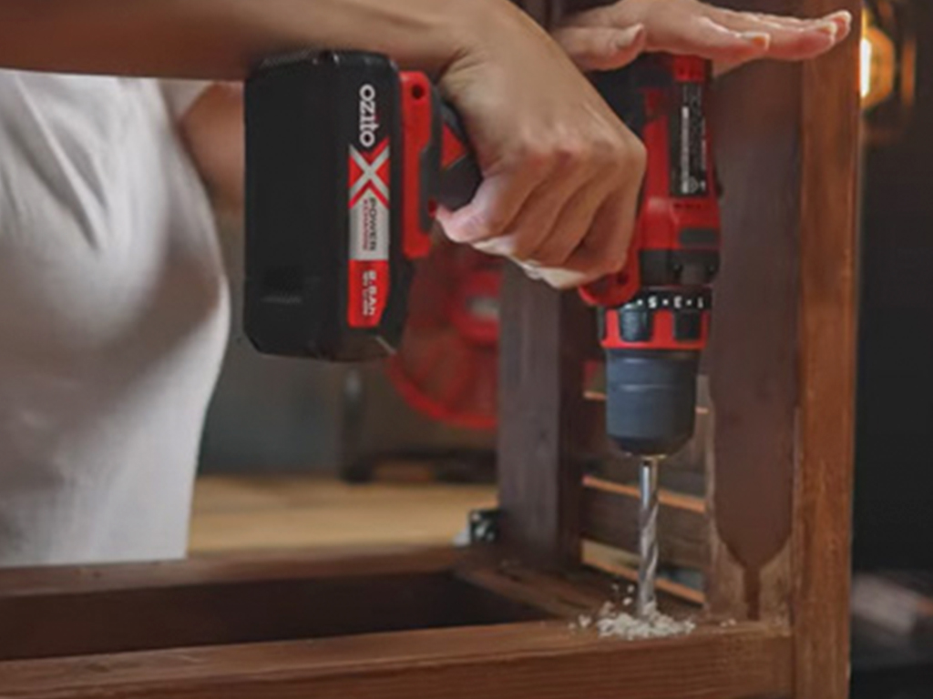 a man is drilling a hole with a cordless screwdriver