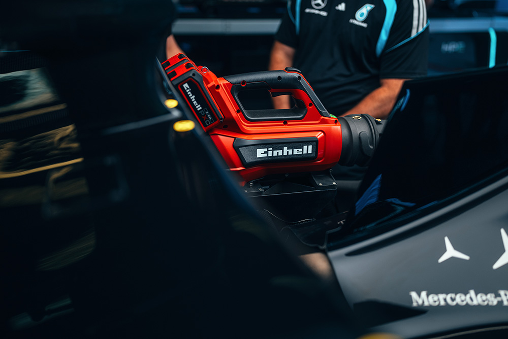 Person using an Einhell cordless screwdriver inside a vehicle.